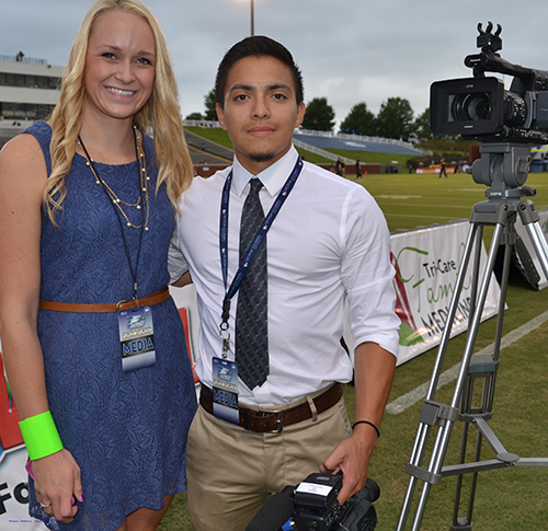 Elaina Lanson and Cesar Perez working with ESPN at football game