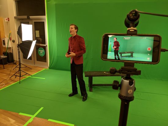 Man singing in front of green screen